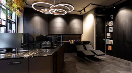 Modern salon interior at Hairsalon Coup D'état, Amsterdam, NL with sleek black design and elegant lighting.