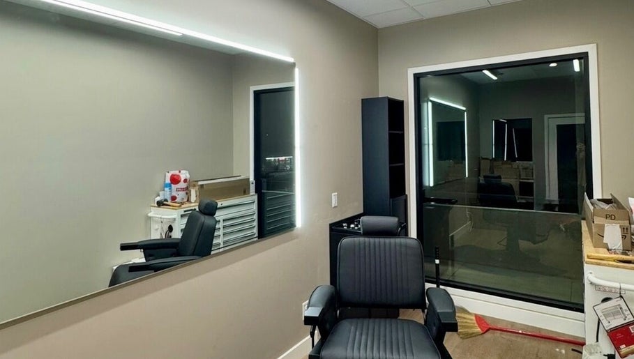 Chic salon interior at Drip Hq in Garden Grove, California, US with black chair and illuminated mirror.
