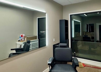 Chic salon interior at Drip Hq in Garden Grove, California, US with black chair and illuminated mirror.
