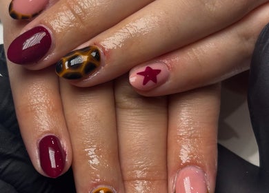 Stylish nail art featuring maroon, tortoiseshell, and star design at The Country Beauty Barn, Castlederg, Northern Ireland, GB.
