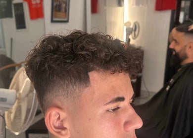 Curly fade hairstyle professionally styled at Cutzbycunha in São Domingos De Rana, Lisboa, PT.