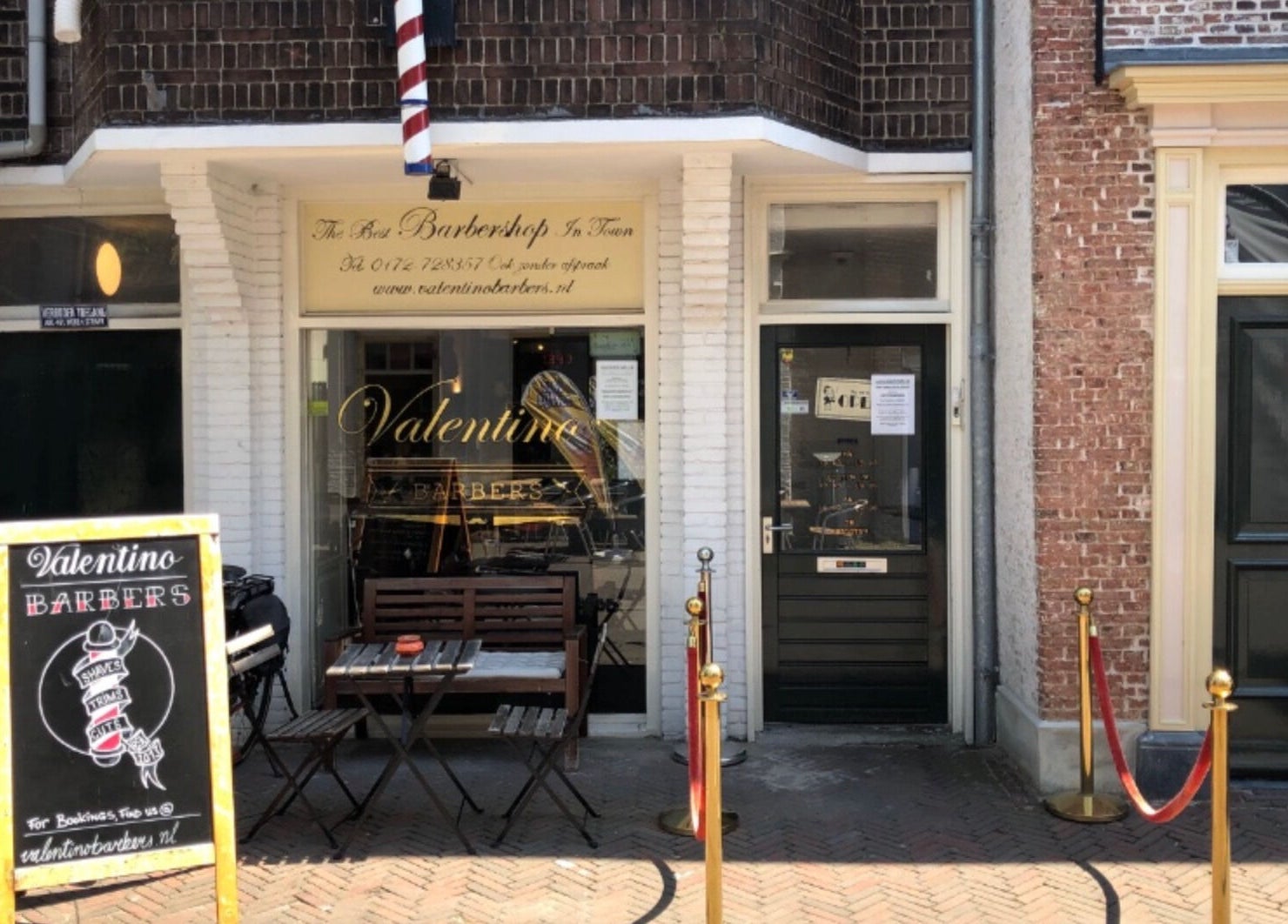 Buitenkant van Valentino Barbers in Alphen aan den Rijn, Zuid-Holland, NL met klassiek uithangbord.