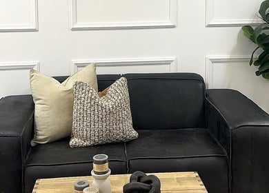 Elegant black sofa with pillows at Mocha Aesthetics Clinic, Johannesburg, Gauteng, ZA for comfort and style.