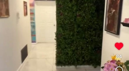Entrance hallway with greenery wall at Pink Lounge Lash | PMU in Louisville, Kentucky, US.