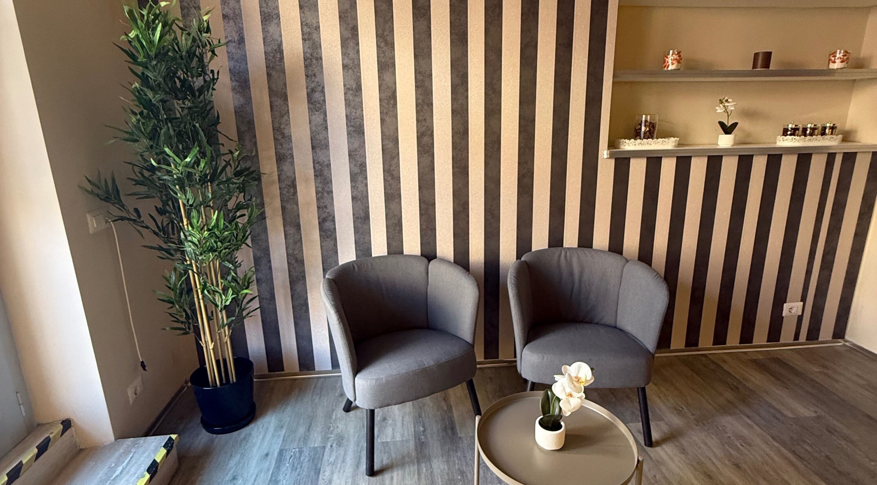 Elegante area d'attesa di Eden Wellness SPA, con sedie grigie e piante, a Roma, Roma, IT.