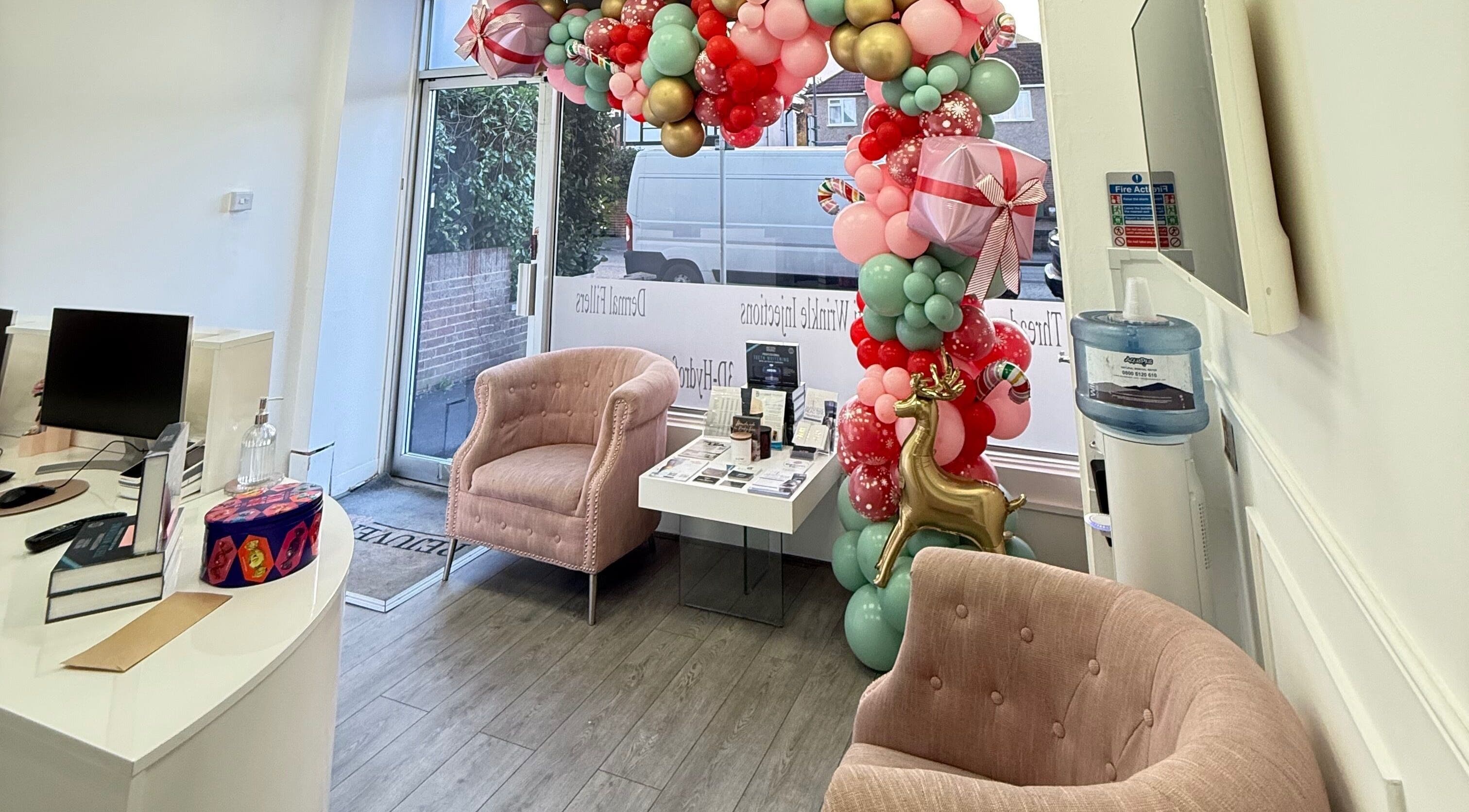 Welcoming decor at Katerina Aesthetics, Sidcup, England, GB featuring elegant balloon arch and cozy seating.