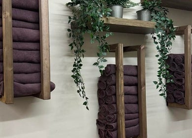 Stylish towel setup at Legally Blonde Hair, Hull, England, GB. Wooden racks with towels and hanging plants.