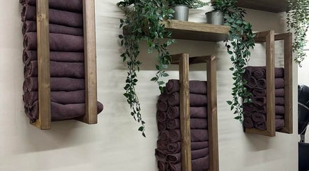 Stylish towel setup at Legally Blonde Hair, Hull, England, GB. Wooden racks with towels and hanging plants.