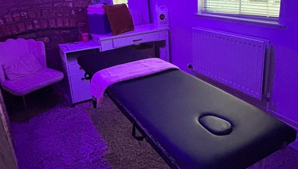 Massage room at Hayley's Health Hub, Knowsley, England, GB with ambient purple lighting and a comfortable treatment bed.
