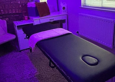 Massage room at Hayley's Health Hub, Knowsley, England, GB with ambient purple lighting and a comfortable treatment bed.