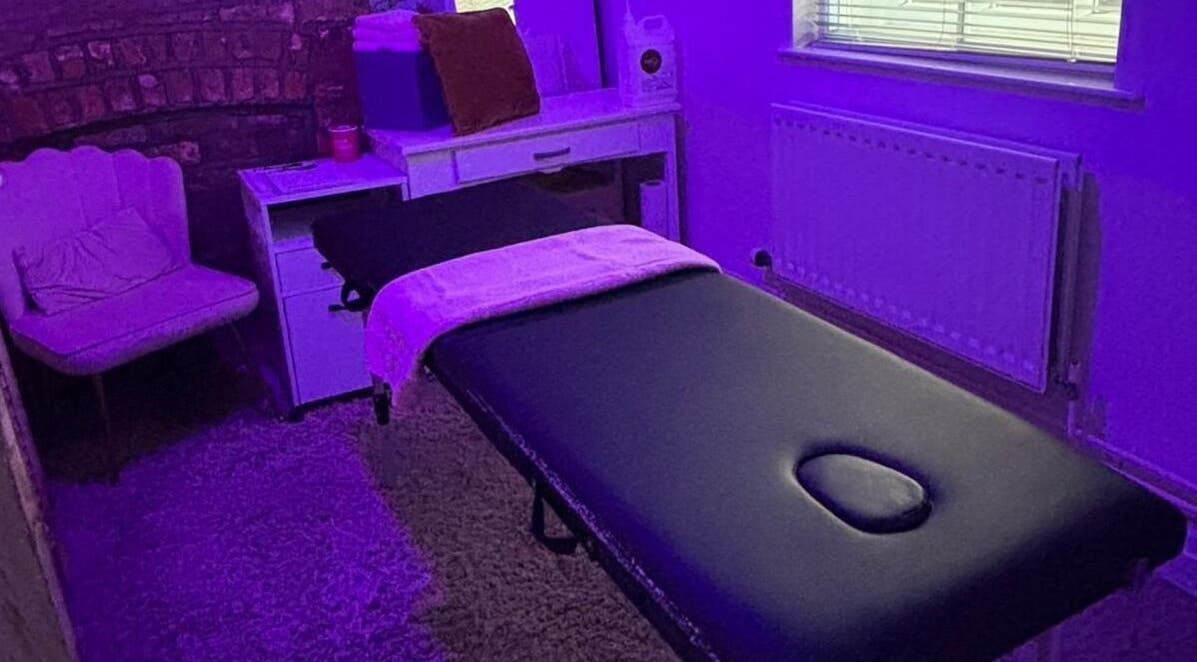 Massage room at Hayley's Health Hub, Knowsley, England, GB with ambient purple lighting and a comfortable treatment bed.