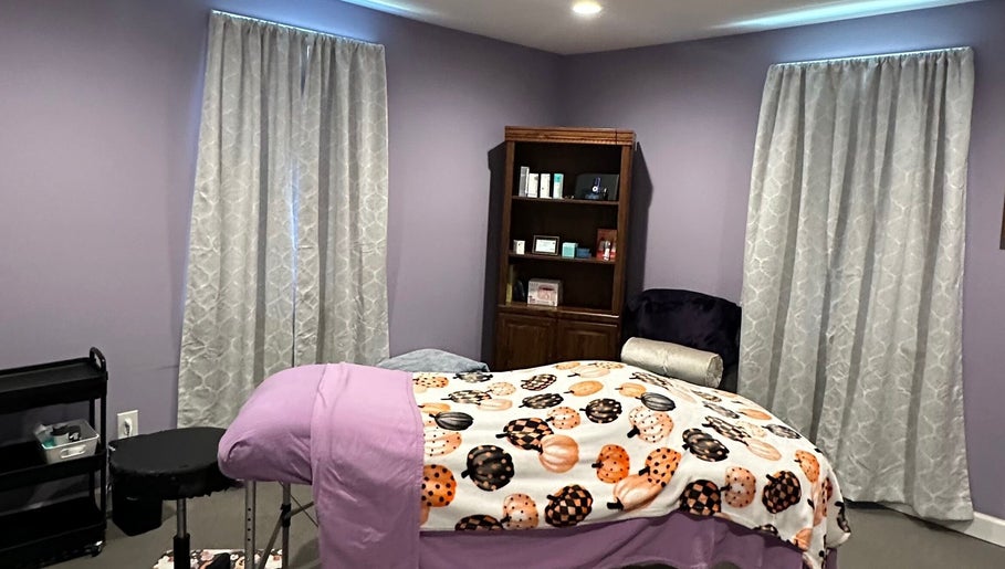 Relaxing spa room at Beautifully Layered Skin, Kernersville, North Carolina, US, featuring a bed with purple decor.