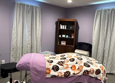 Relaxing spa room at Beautifully Layered Skin, Kernersville, North Carolina, US, featuring a bed with purple decor.