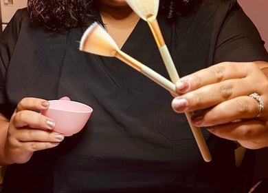Beautician holding brushes at Beautifully Layered Skin, Kernersville, North Carolina, US.