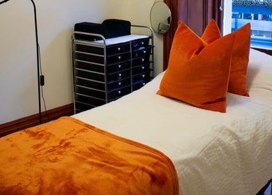 Therapy room at Beauty By Aimee with orange accents in Dundee, Scotland, GB. Cozy treatment space.