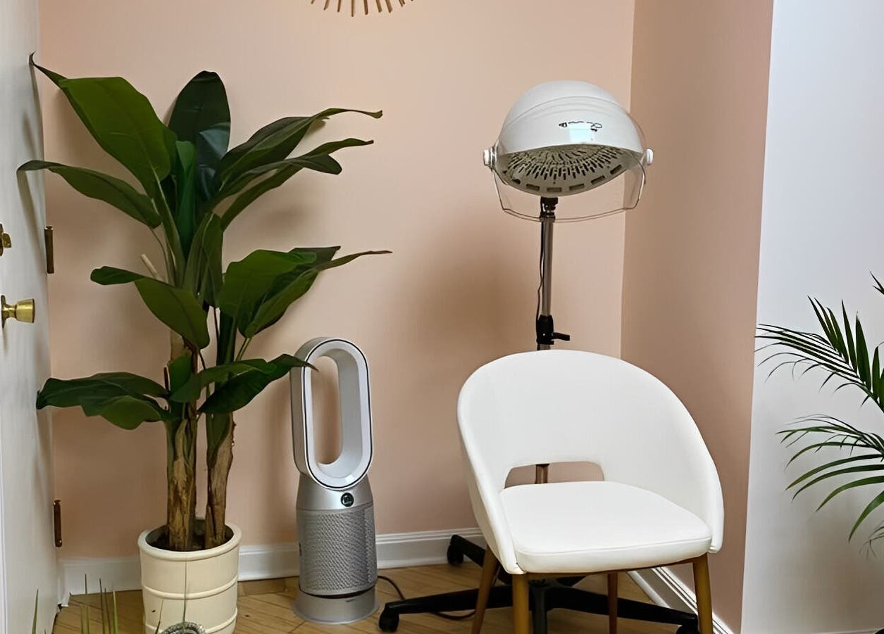 Cozy corner at Sarah Helena, Toronto, Ontario, CA featuring a chair, plants, and salon equipment.