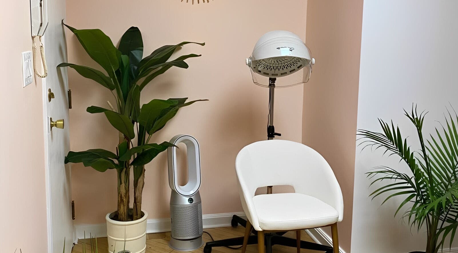 Cozy corner at Sarah Helena, Toronto, Ontario, CA featuring a chair, plants, and salon equipment.