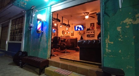 Entrada de HH Altair's Barbershop Reborn en El Cooperativo, Estado De México, MX, iluminada por la noche.