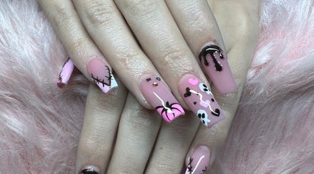 Diseño único de uñas rosadas en Medusa Nails, Greenacres, Florida, US, con detalles artísticos en negro.