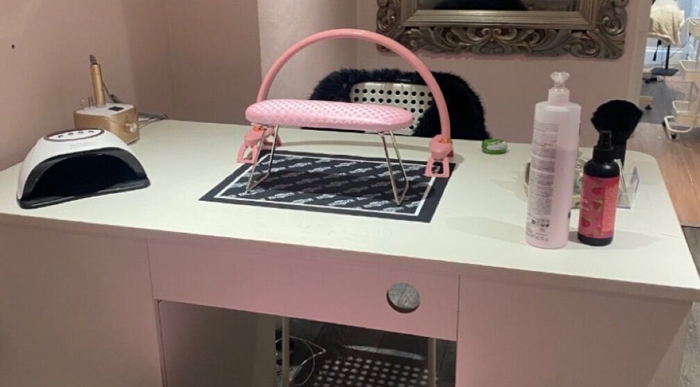 Elegant nail desk at Nail Kouture, Wolverhampton, England, GB, with manicure tools and pink armrest.