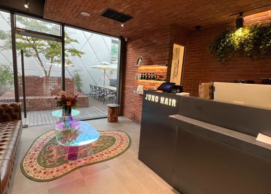 Interior of JUNO Hair Garden Dosan 花园都山店 ガーデン・ドサン店 in 서울특별시, KR with stylish seating and decor.