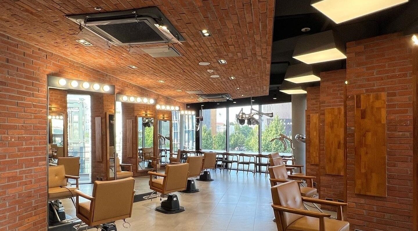 Inside JUNO Hair Garden Dosan with stylish chairs and mirrors. Located at 서울특별시, 서울특별시, KR.