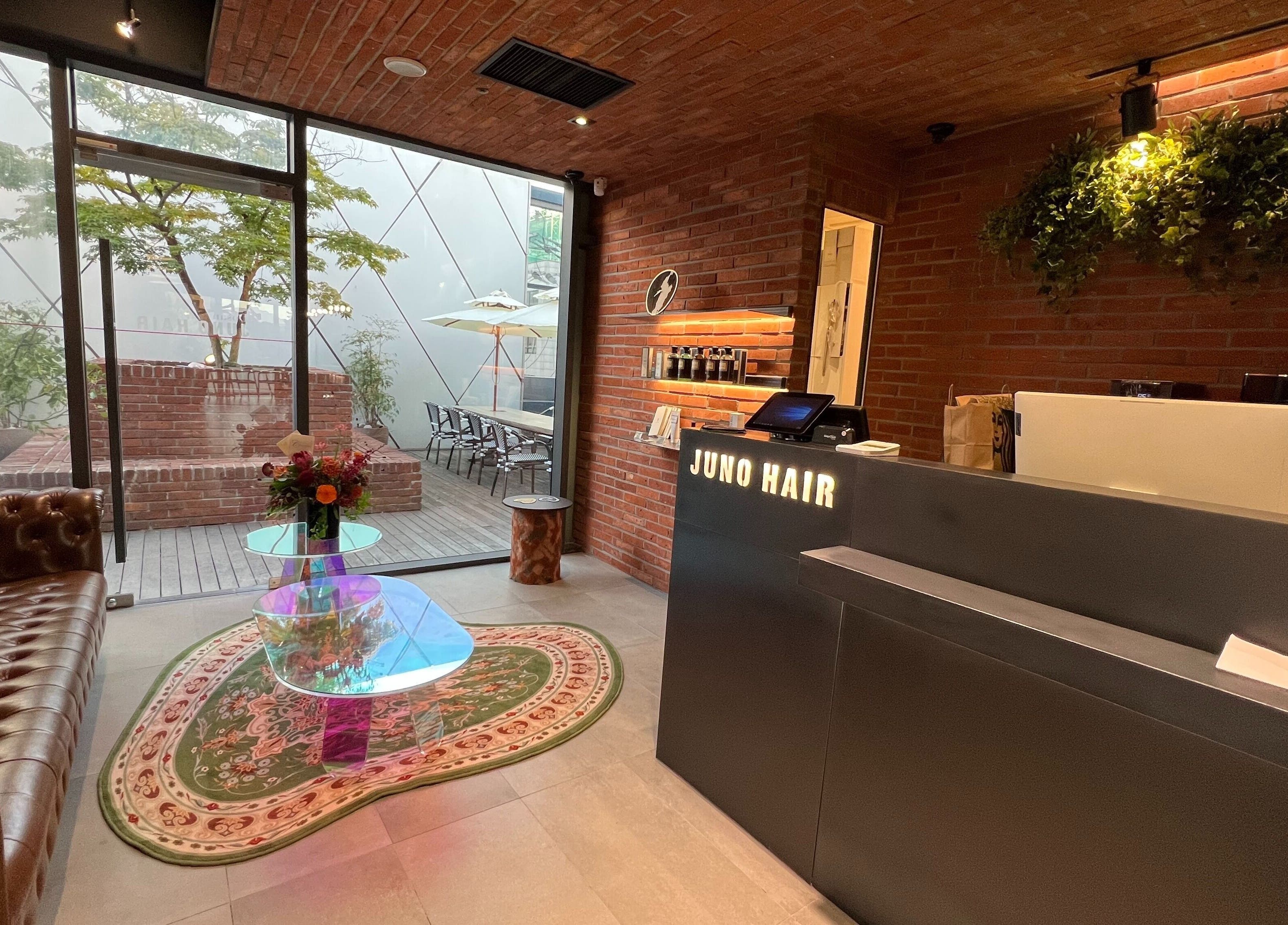 JUNO Hair Garden Dosan's stylish reception area in 서울특별시, featuring chic decor and inviting seating.