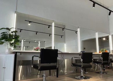 Modern salon design at Ocean hair salon in Melbourne, Victoria, AU with sleek chairs and mirrors.