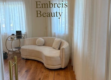 Cozy, elegant waiting area at Embreis Beauty, Auckland, NZ with plush seating and gentle lighting.