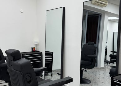 Prefinjen studio AS Barbershop v Ljubljani, Ljubljana, SI z modernimi črnimi stoli in ogledali.