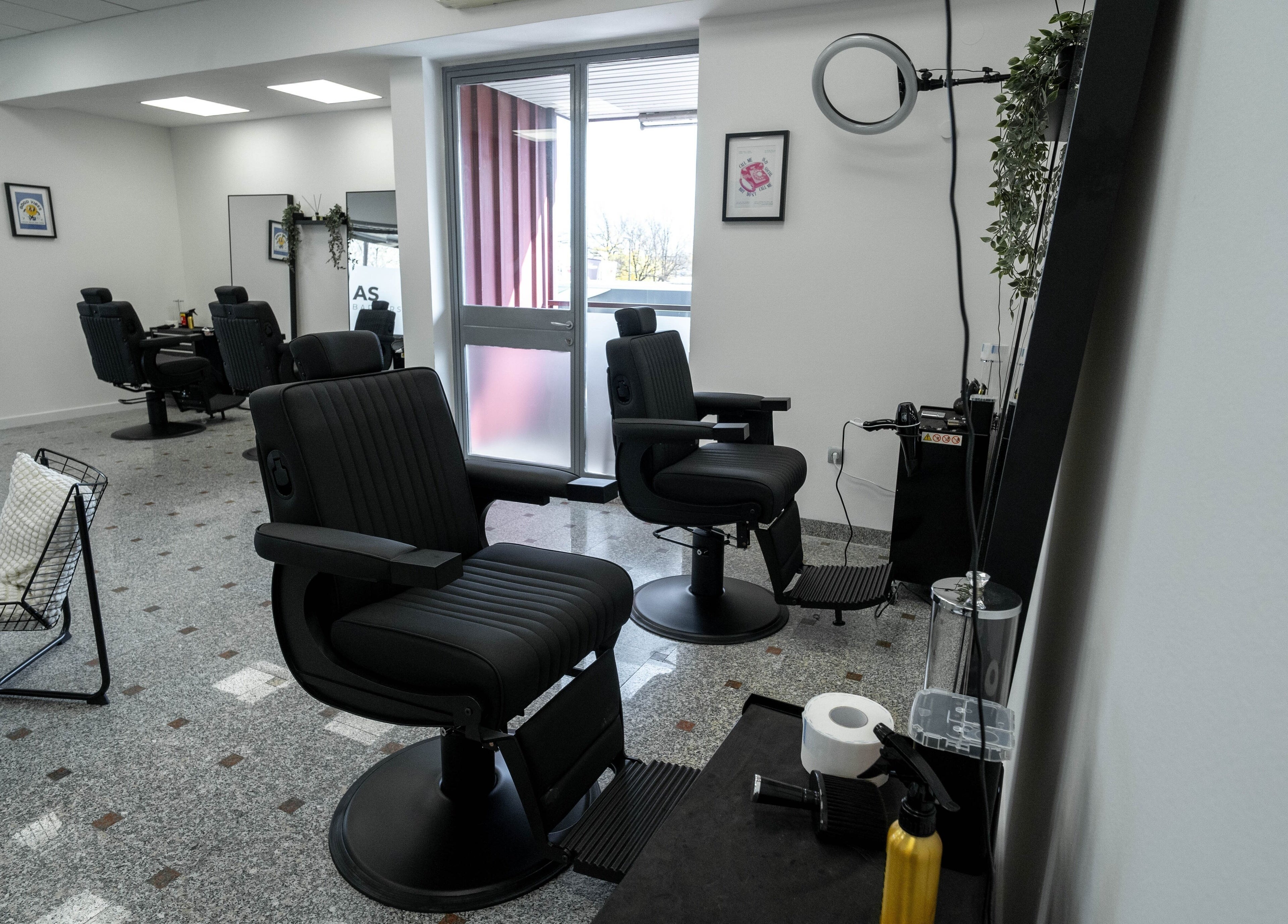 Sodoben notranji prostor AS Barbershop v Ljubljani, Ljubljana, SI s stilskimi stoli in opremo.