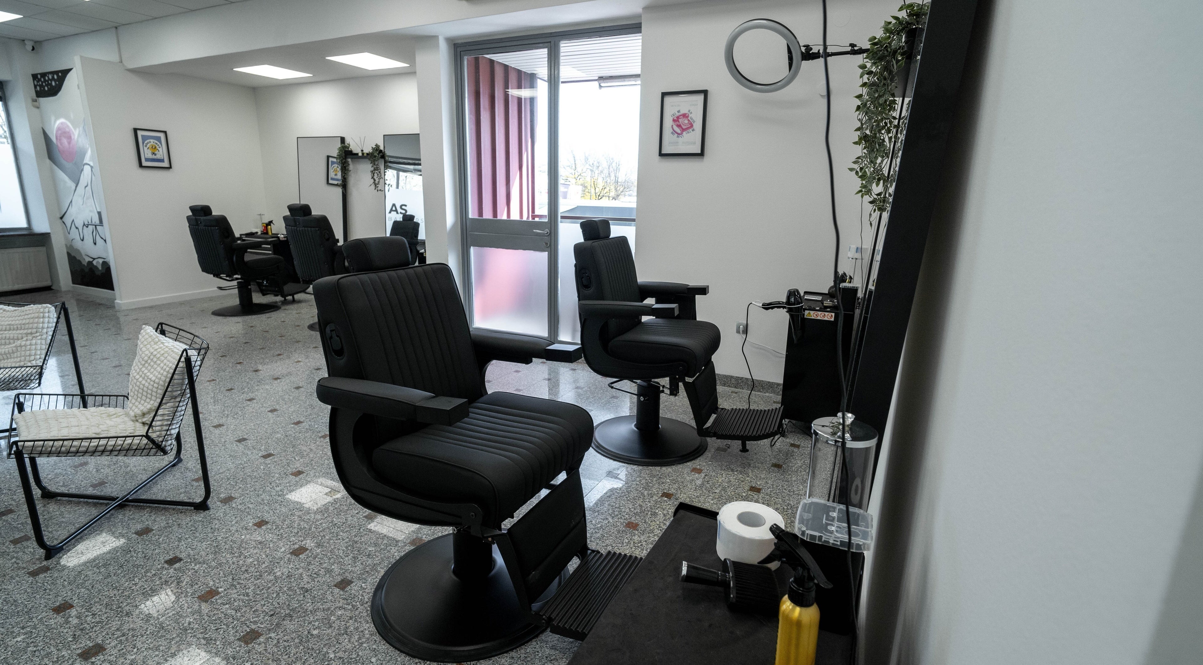 Sodoben notranji prostor AS Barbershop v Ljubljani, Ljubljana, SI s stilskimi stoli in opremo.