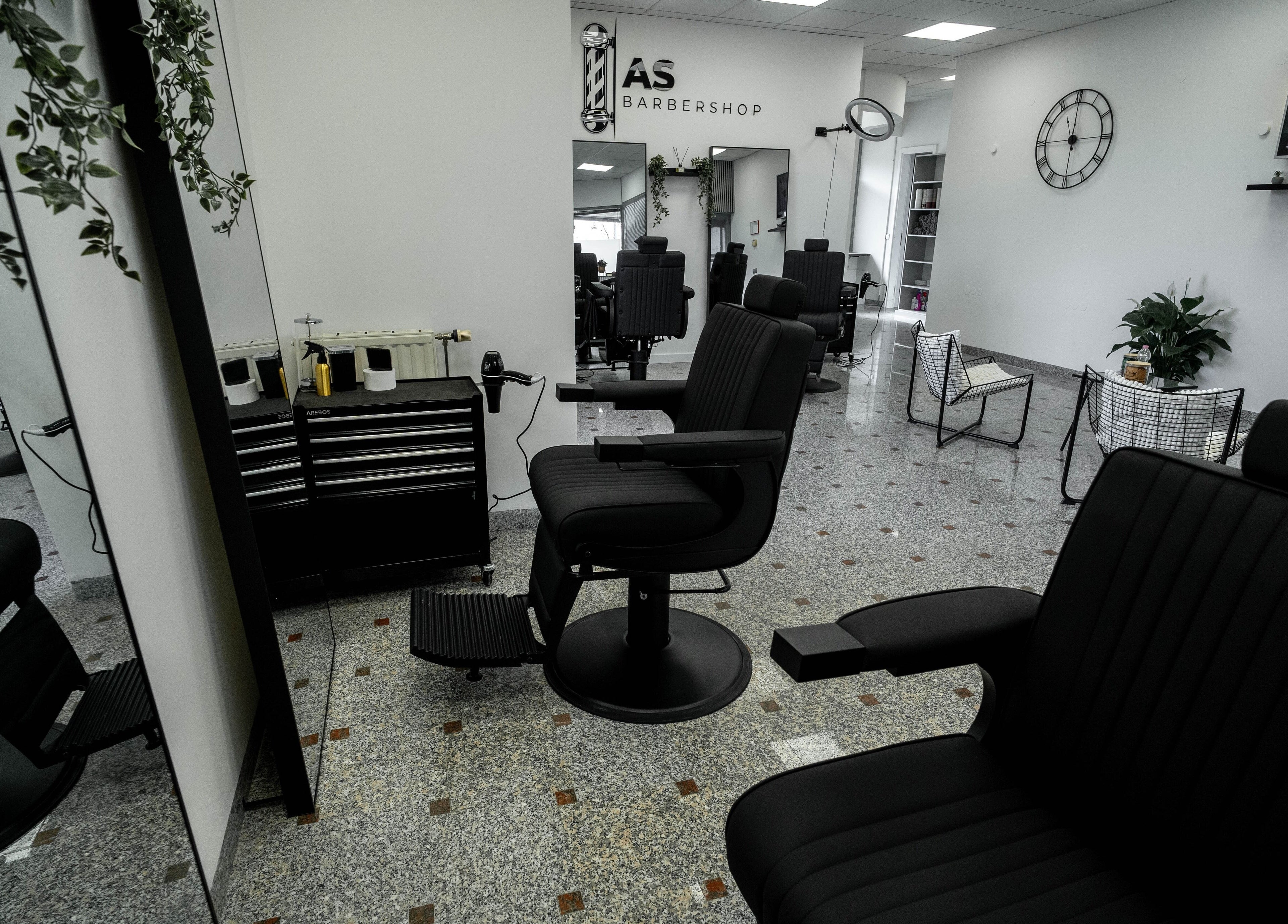 Elegant notranjost AS Barbershop v Ljubljani, Ljubljana, SI, z modernimi stoli in dekoracijo.