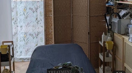 Serene treatment room at Samila Gama, London, England featuring massage table and calming decor.