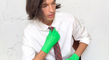 Person in tie and green gloves at FACIAL REBOOT, Milano, Lombardia, IT, showcasing unique style and wellness.