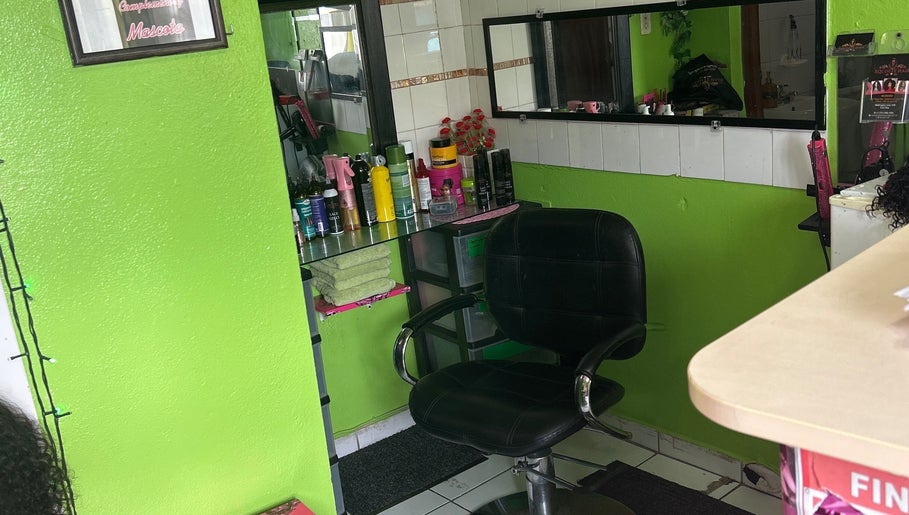 Hair styling chair and products at XQUISITE HAIR, Cole Bay, Sint Maarten, SX with vibrant green walls.