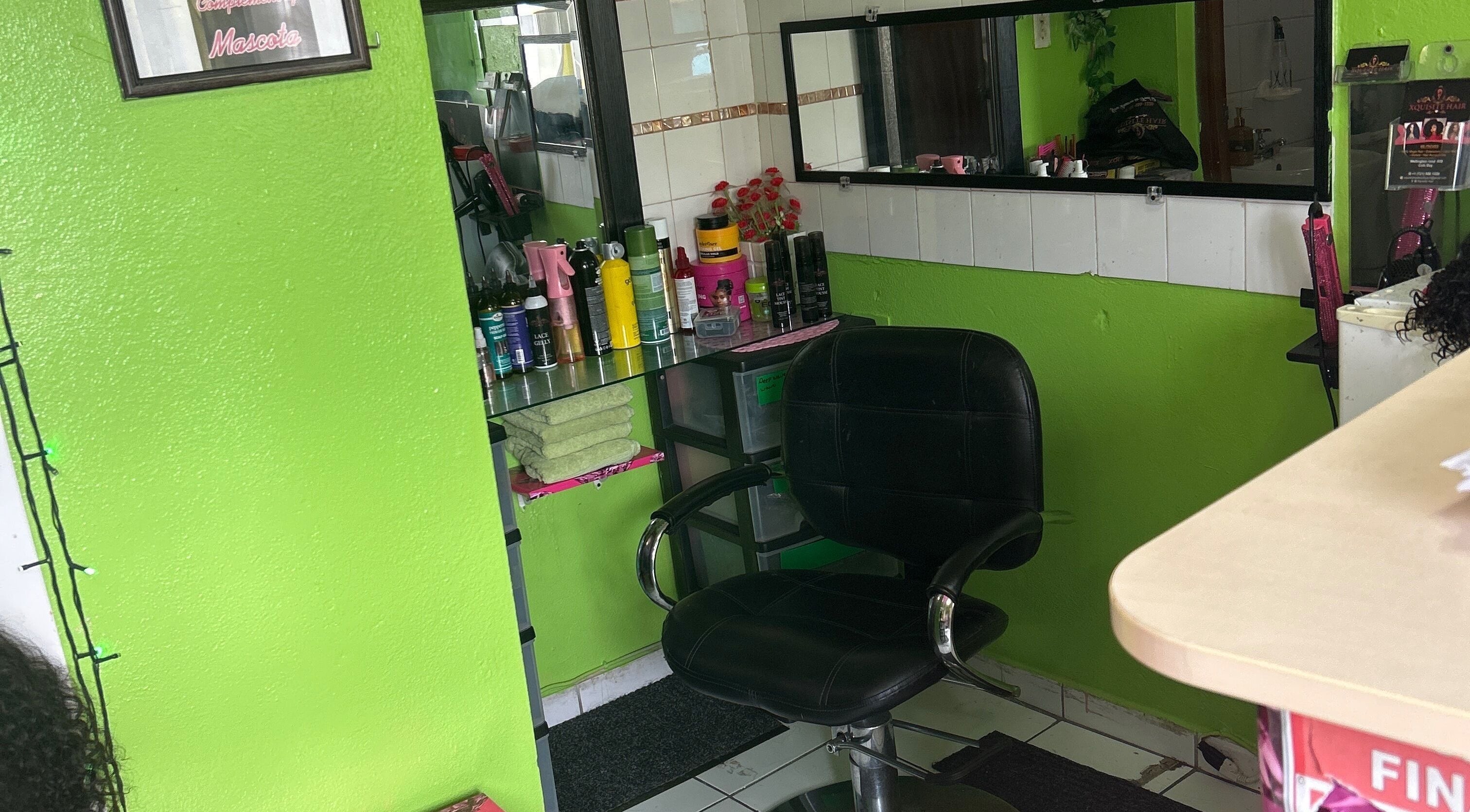 Hair styling chair and products at XQUISITE HAIR, Cole Bay, Sint Maarten, SX with vibrant green walls.