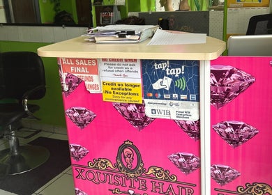 Reception desk at XQUISITE HAIR, Cole Bay, Sint Maarten, SX with salon chair and vibrant decor.