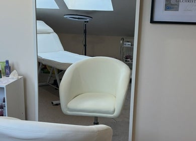 Relaxing treatment room at EmpowerHer Beauty in Edinburgh, Scotland, GB, with plush seating and soothing décor.