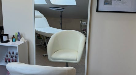 Relaxing treatment room at EmpowerHer Beauty in Edinburgh, Scotland, GB, with plush seating and soothing décor.