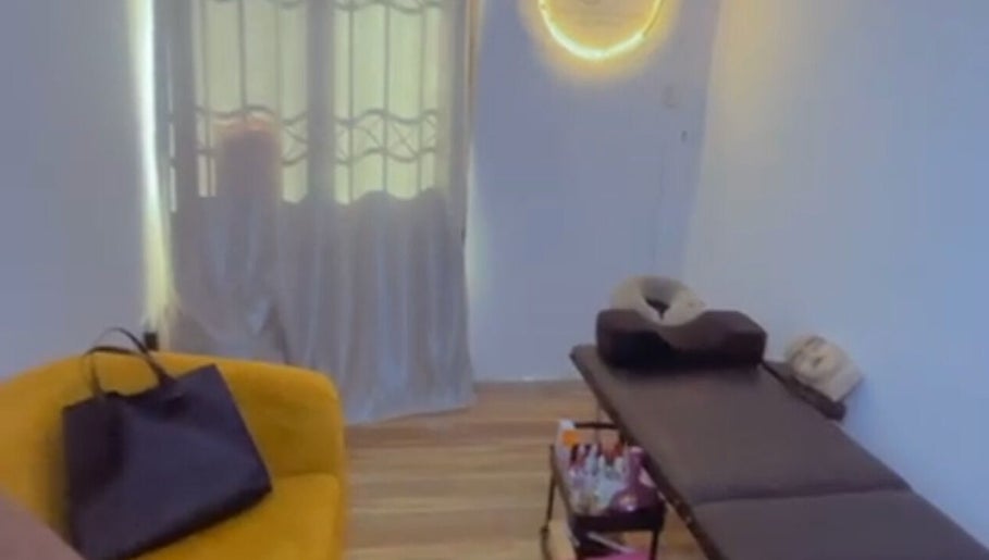 Cozy spa room at EverythingblessingXaesthetic, Lekki, Lagos, NG with massage table and yellow seating.
