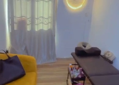 Cozy spa room at EverythingblessingXaesthetic, Lekki, Lagos, NG with massage table and yellow seating.