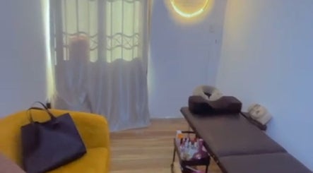 Cozy spa room at EverythingblessingXaesthetic, Lekki, Lagos, NG with massage table and yellow seating.