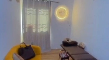 Relaxing room at Everythingblessing Xaesthetic in Lekki, Lagos, NG with a yellow chair and massage table.