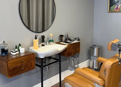 Sleek barber station at Sina Grooming Atelier, Winchester, England, GB, featuring modern chair and grooming tools.