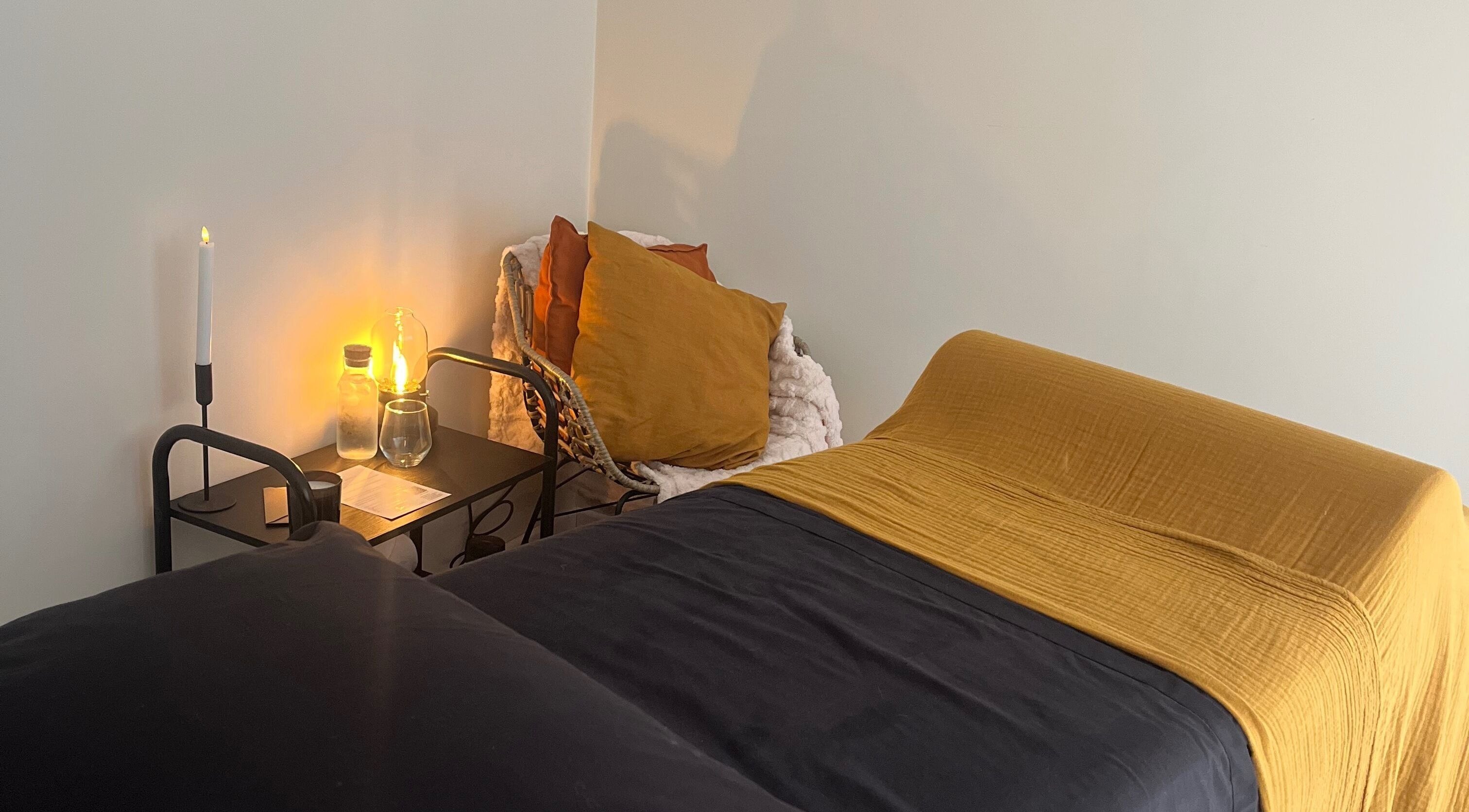 Relaxing treatment room at The Secret Retreat, Longridge, England, GB, with ambient lighting and plush bedding.