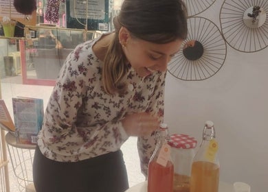 Mulher sorrindo ao preparar bebidas naturais em Conect Nature, Agualva-cacém, Lisboa, PT.