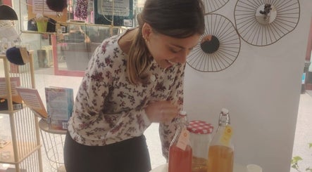 Mulher sorrindo ao preparar bebidas naturais em Conect Nature, Agualva-cacém, Lisboa, PT.
