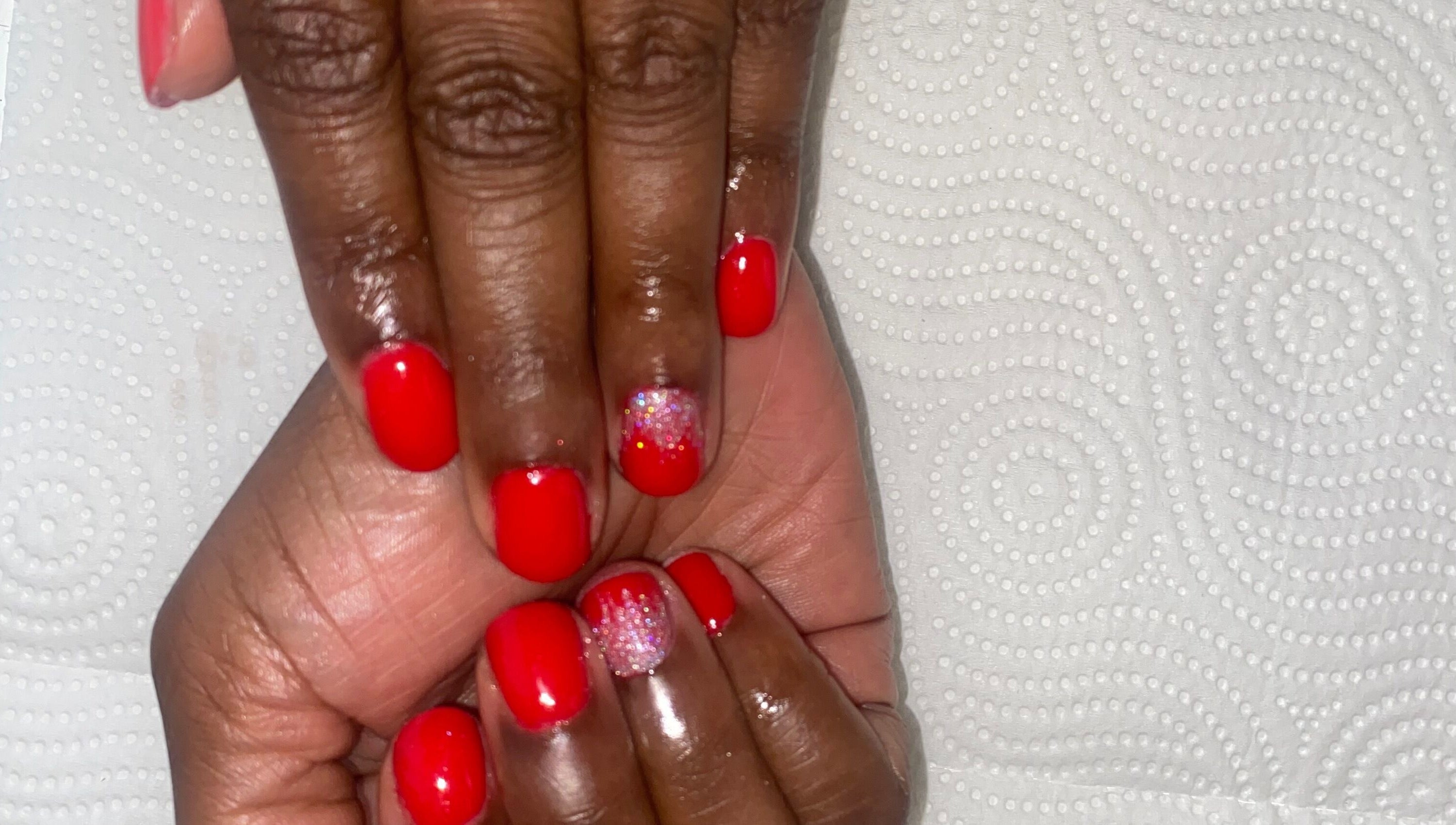 Vibrant red manicure with glitter accent from Claws & Effect in Randburg, Gauteng, ZA.