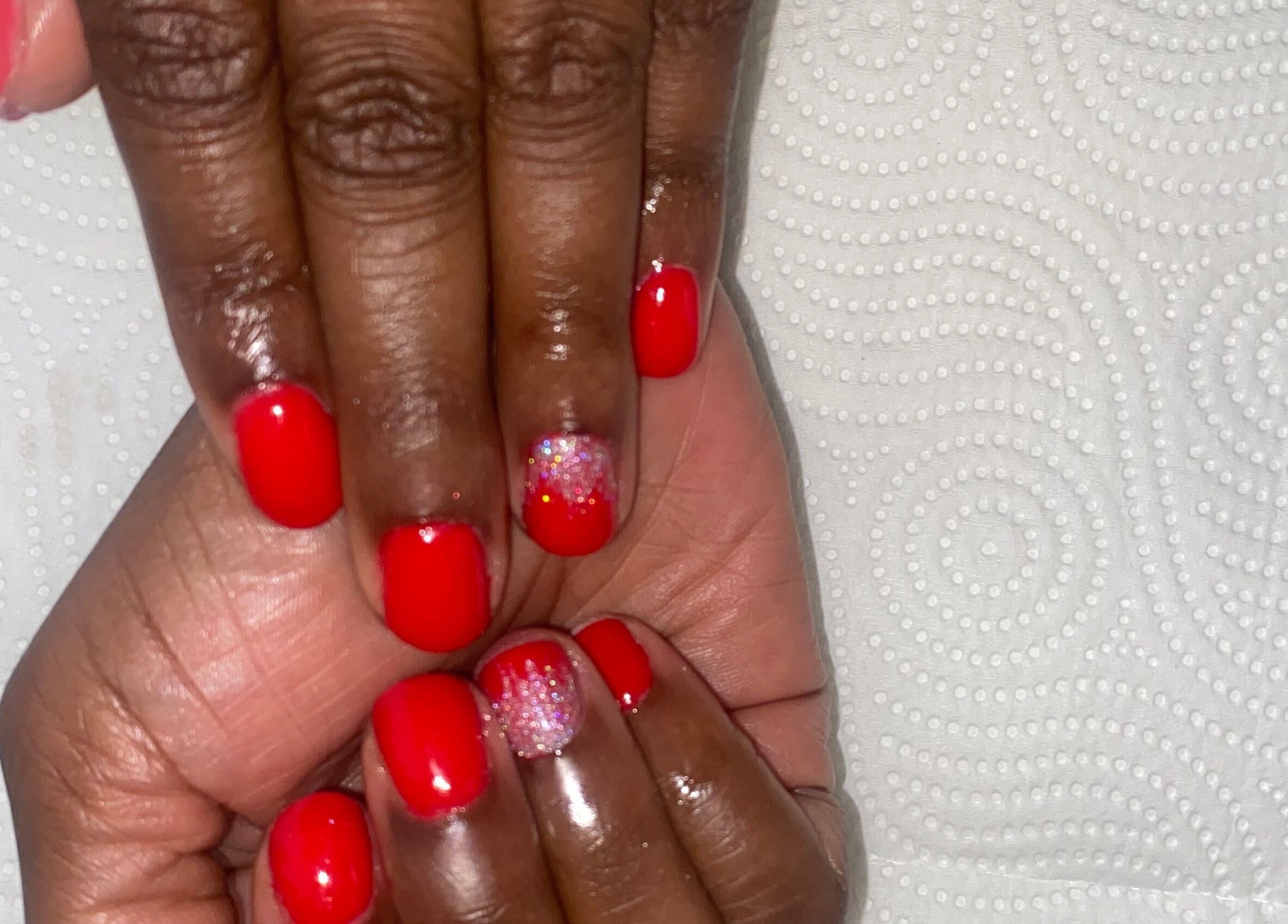 Vibrant red manicure with glitter accent from Claws & Effect in Randburg, Gauteng, ZA.
